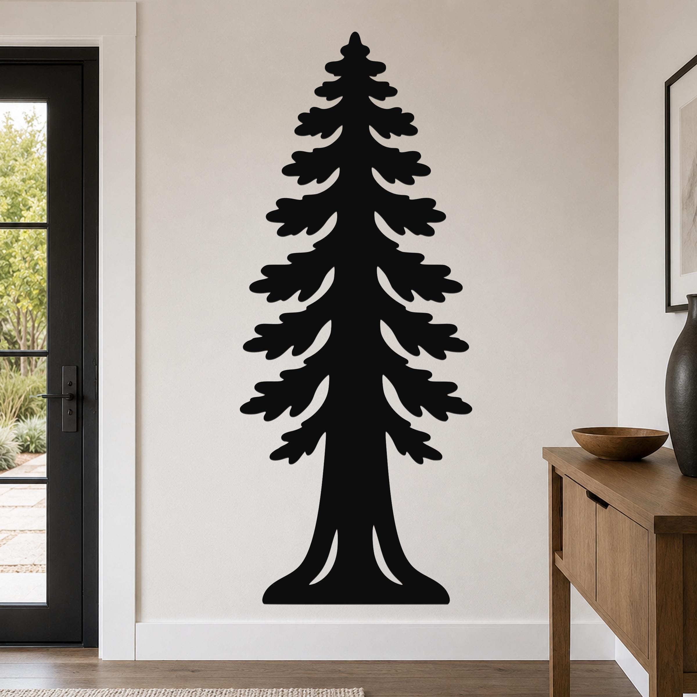 Black metal wall art in the silhouette of a sequoia tree with layered branches and a wide base, mounted on a light-colored wall in a living room.