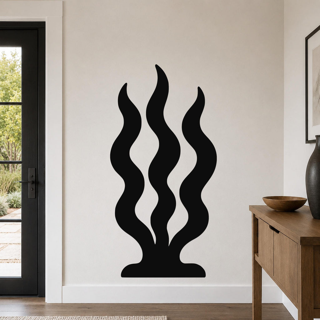Black metal wall art with a wavy, seaweed-like silhouette, mounted on a light-colored wall in a modern entryway.