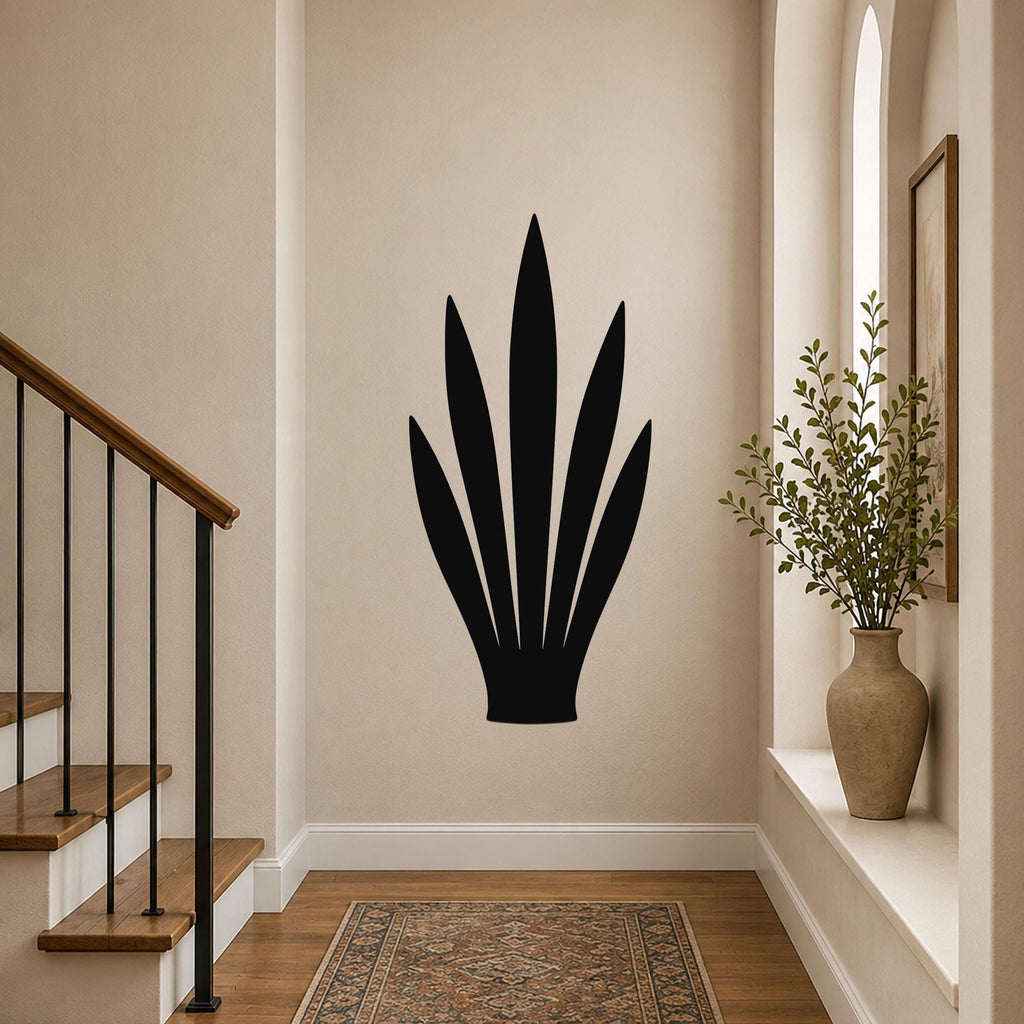 Black metal wall art in a snake plant silhouette, mounted on a hallway wall above a patterned rug near a staircase.