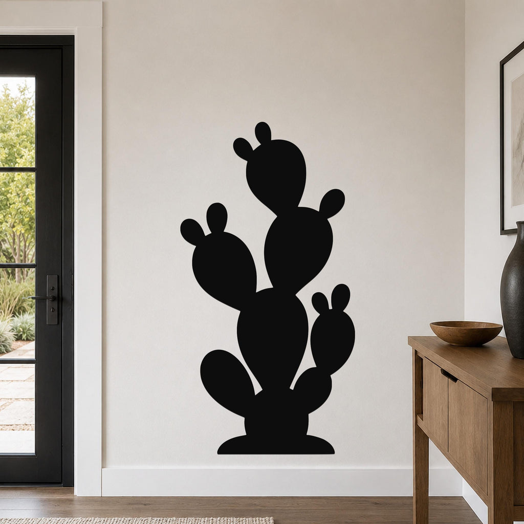 Black metal wall art in the silhouette of a prickly pear cactus, mounted on a light-colored wall in a modern entryway.