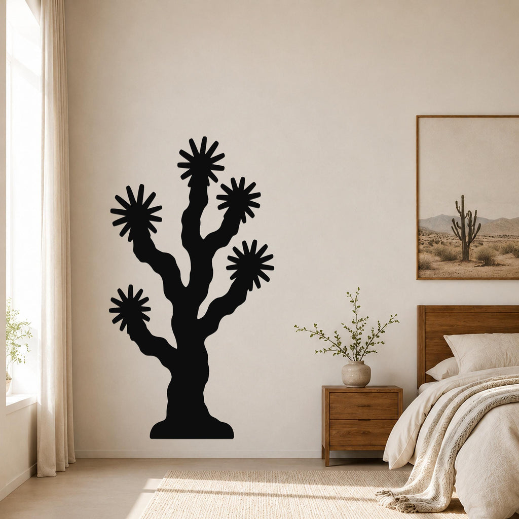 Black metal Joshua tree wall art with starburst cutouts, mounted on a bedroom wall above a nightstand.