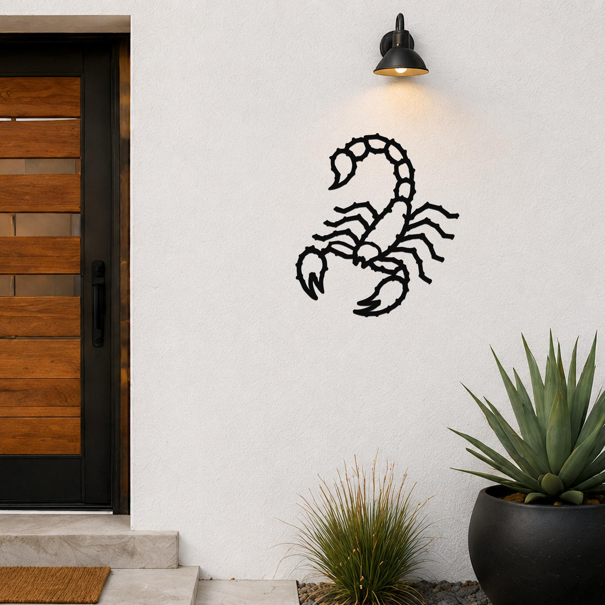 Black metal scorpion wall art with detailed cutout design, mounted on an outdoor wall beside a wooden door and potted plants.