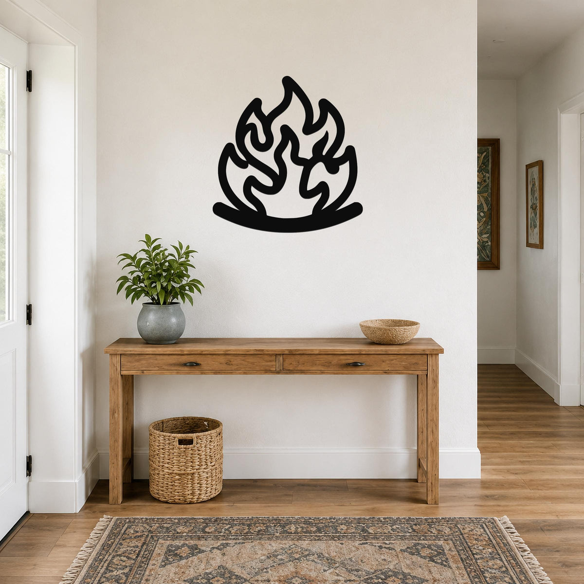 Black metal wall art in a flame silhouette design, mounted above a wooden console table in a hallway.