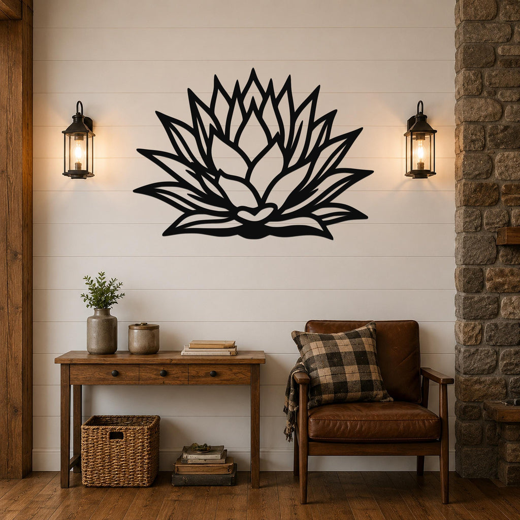 Black metal agave wall sculpture with layered leaf cutouts, mounted on a shiplap wall above a wooden console table in a living room.