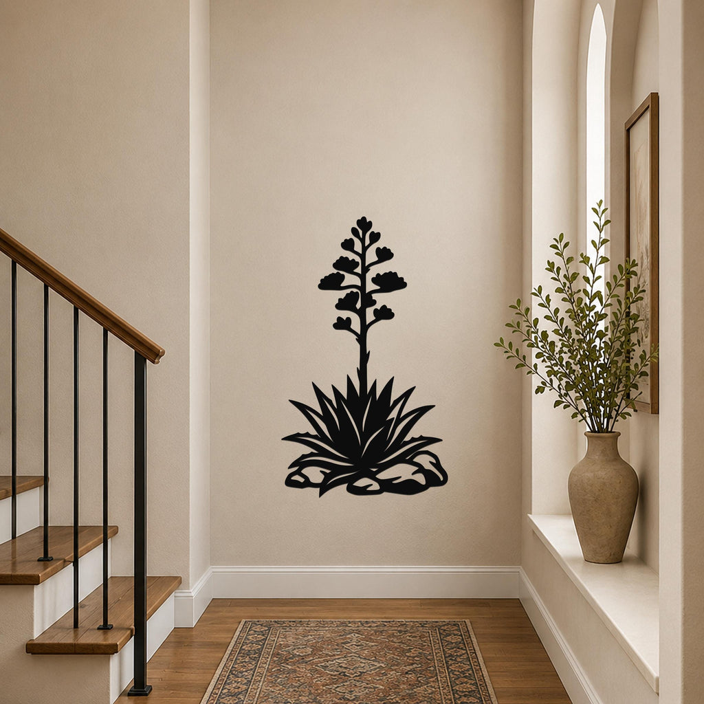 Black metal agave wall art with a blooming flower silhouette, mounted on a hallway wall above a patterned rug.
