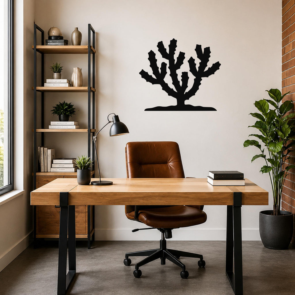 Black metal Cholla cactus wall art with branching silhouette, mounted on a light-colored wall above a wooden desk in a home office.