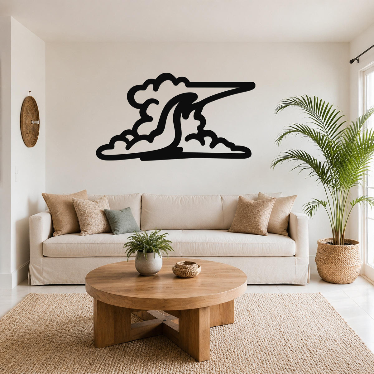 Black metal cloud wall art with a flowing, wave-like silhouette, mounted above a beige sofa in a living room.