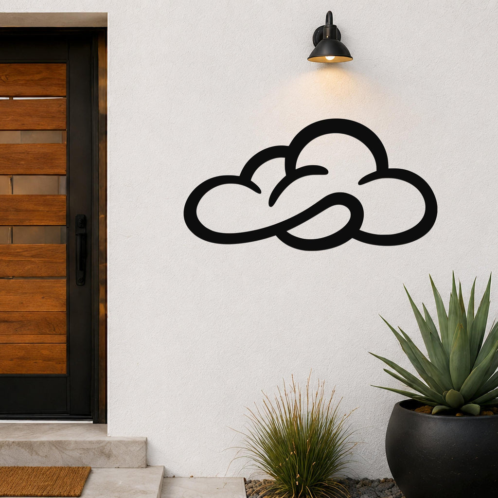 Black metal cloud wall art with open silhouette design, mounted on a white exterior wall above a potted succulent and near a wooden front door.