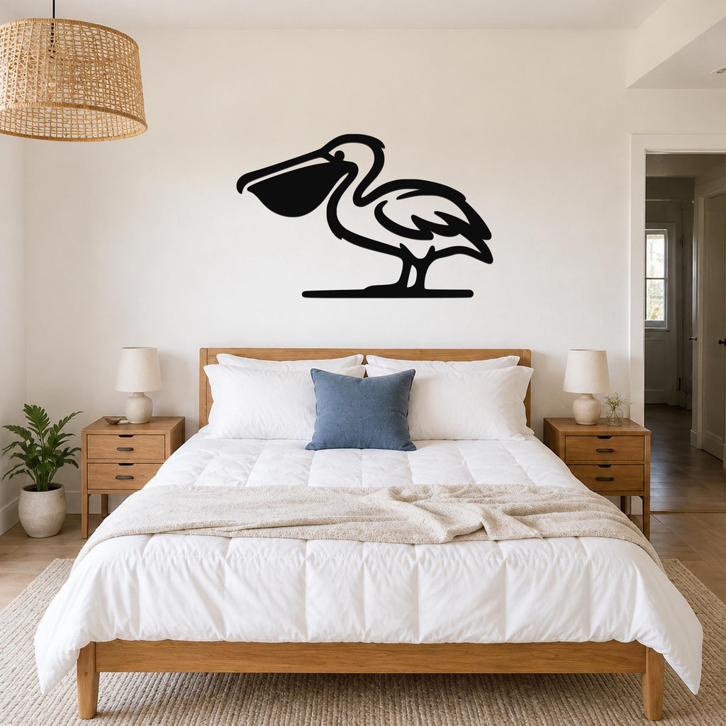 Black metal pelican wall art silhouette mounted above a bed in a bright bedroom.