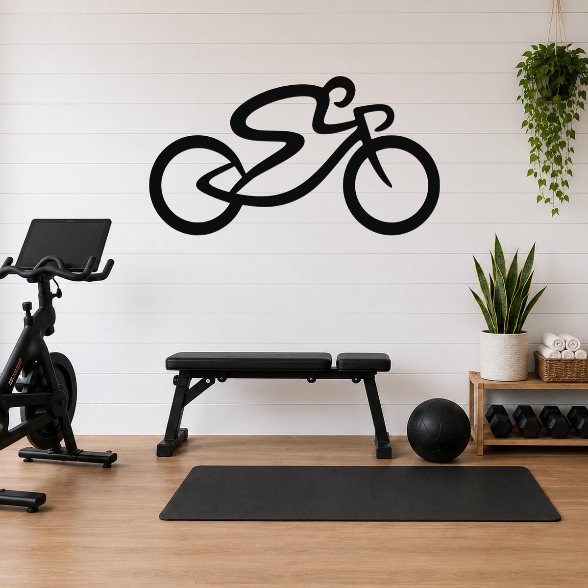 Black metal wall art in a bold cycling silhouette, mounted on a white shiplap wall above a workout bench in a home gym.