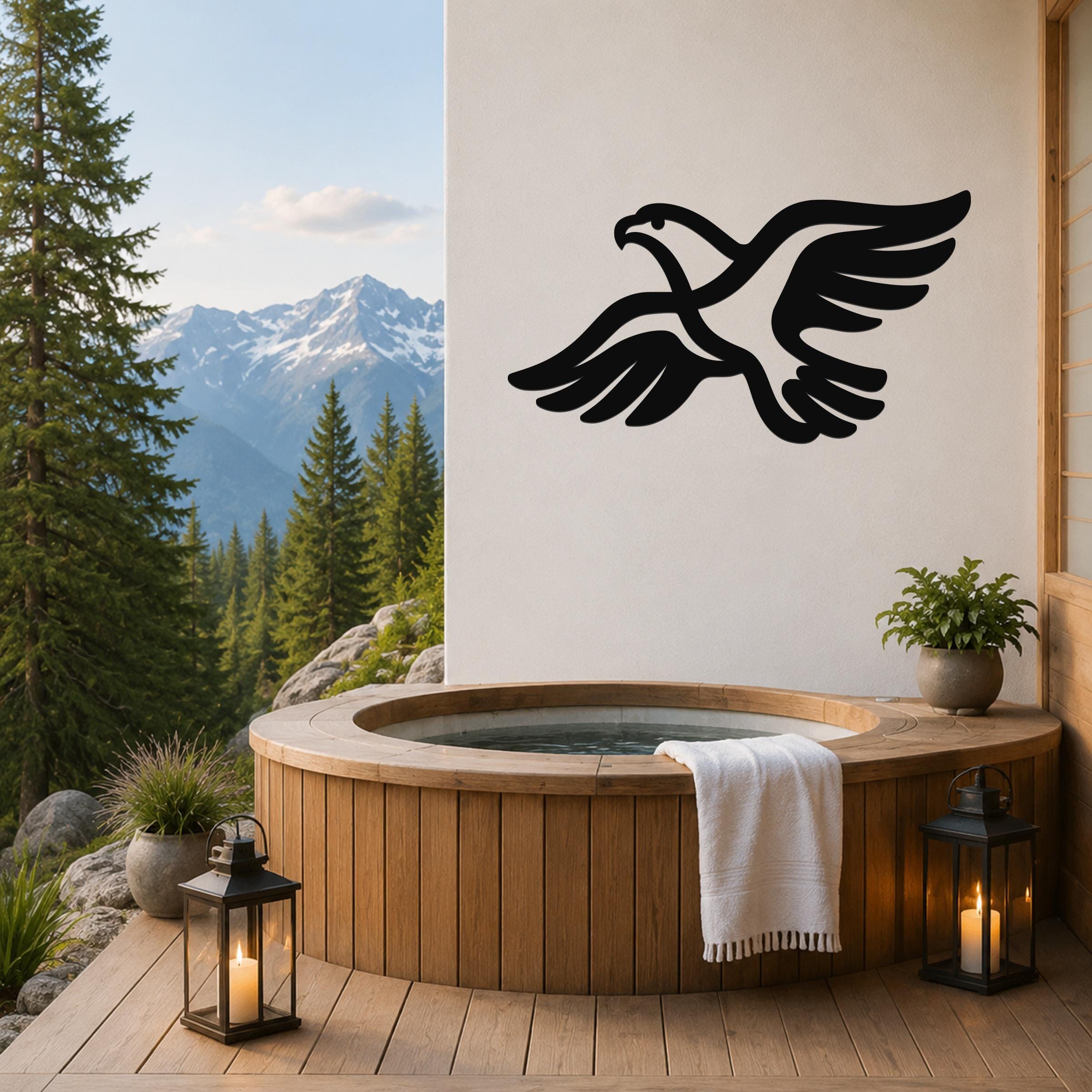 Black metal eagle wall art with outstretched wings silhouette, mounted on a white wall above a wooden hot tub on a mountain-view deck.