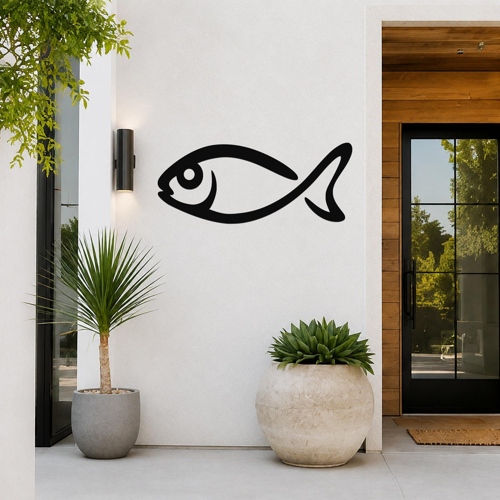 Black metal fish silhouette wall art mounted on a white exterior wall beside a glass door and potted plants.