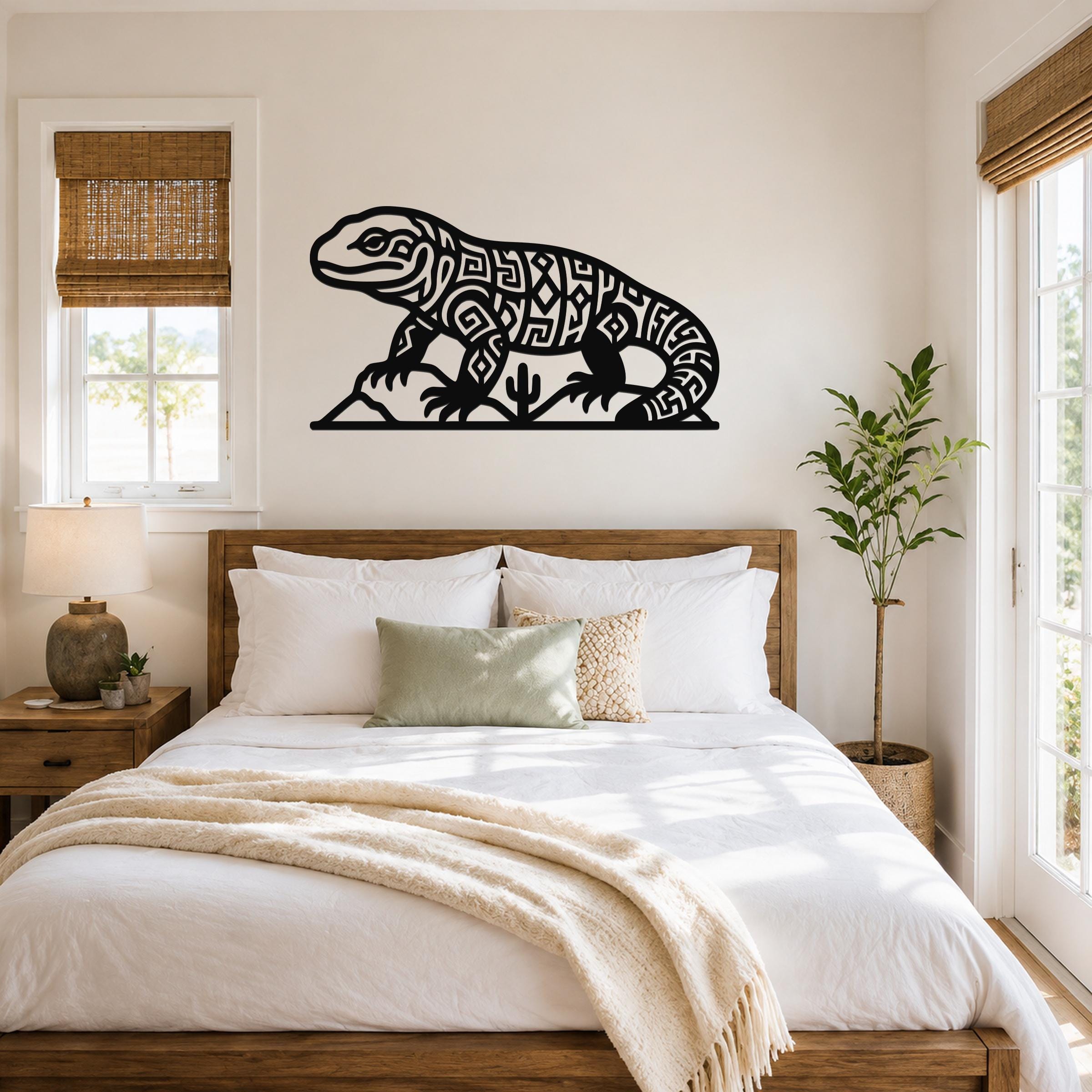 Black metal wall art of a Gila monster with intricate geometric cutouts, mounted above a bed in a bright bedroom.