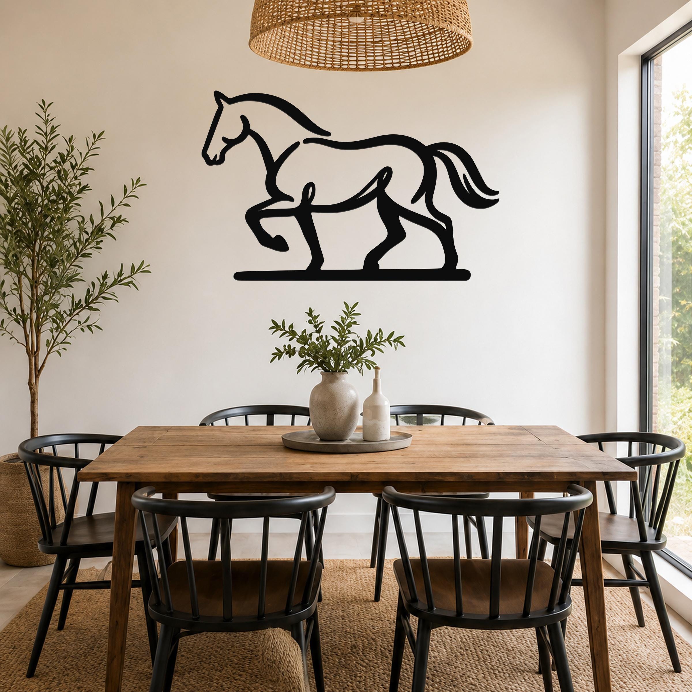 Black metal horse wall art silhouette with motion-line cutouts, mounted above a wooden dining table in a bright dining room.
