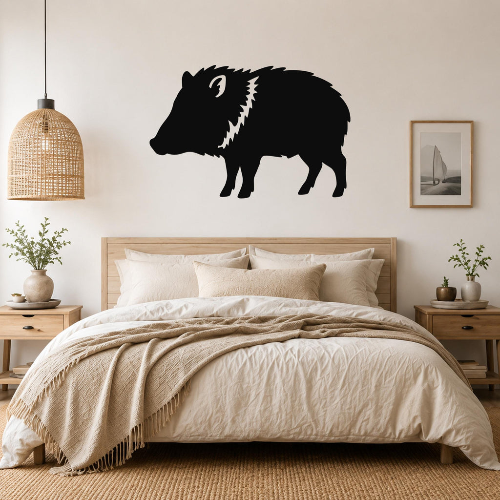 Black metal javelina wall art silhouette with white mane detail, mounted above a wooden bed in a neutral bedroom.