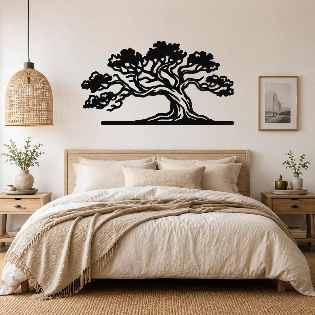 Black metal juniper tree wall art with detailed branch cutouts, mounted above a bed in a neutral bedroom.
