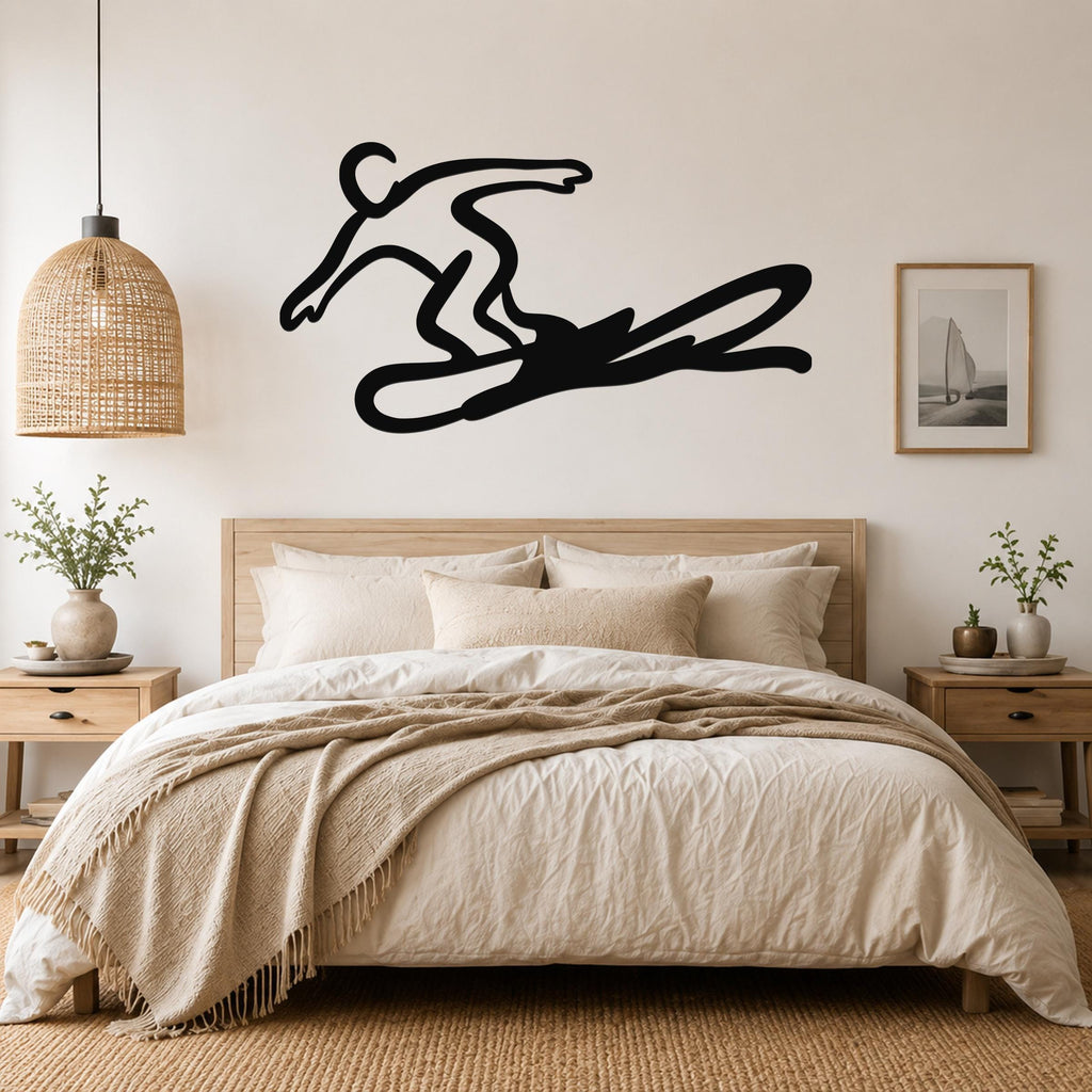 Black metal wall art silhouette of a snowboarder in motion, mounted above a bed in a neutral bedroom.