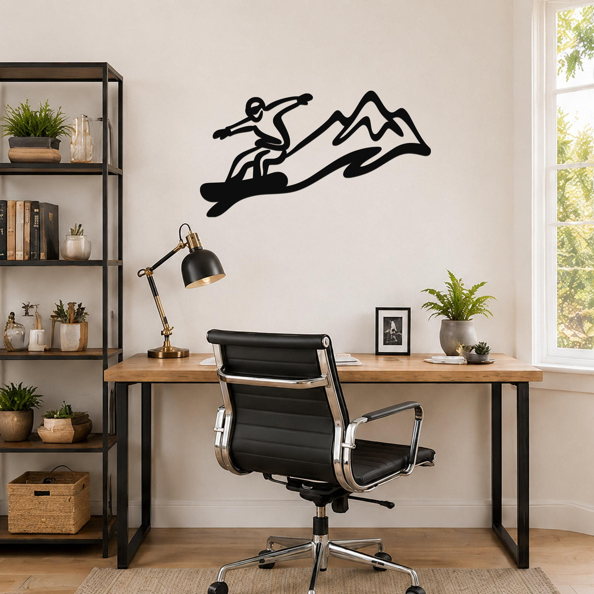 Black metal snowboarder wall art with mountain silhouette, mounted above a wooden desk in a home office.
