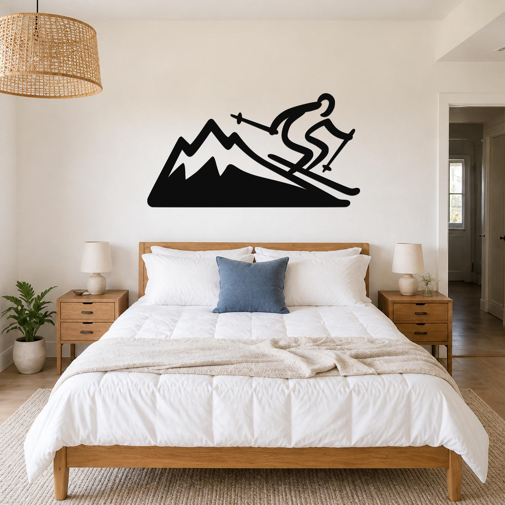Black metal wall sculpture of a skier on a mountain, mounted above a bed in a bedroom.
