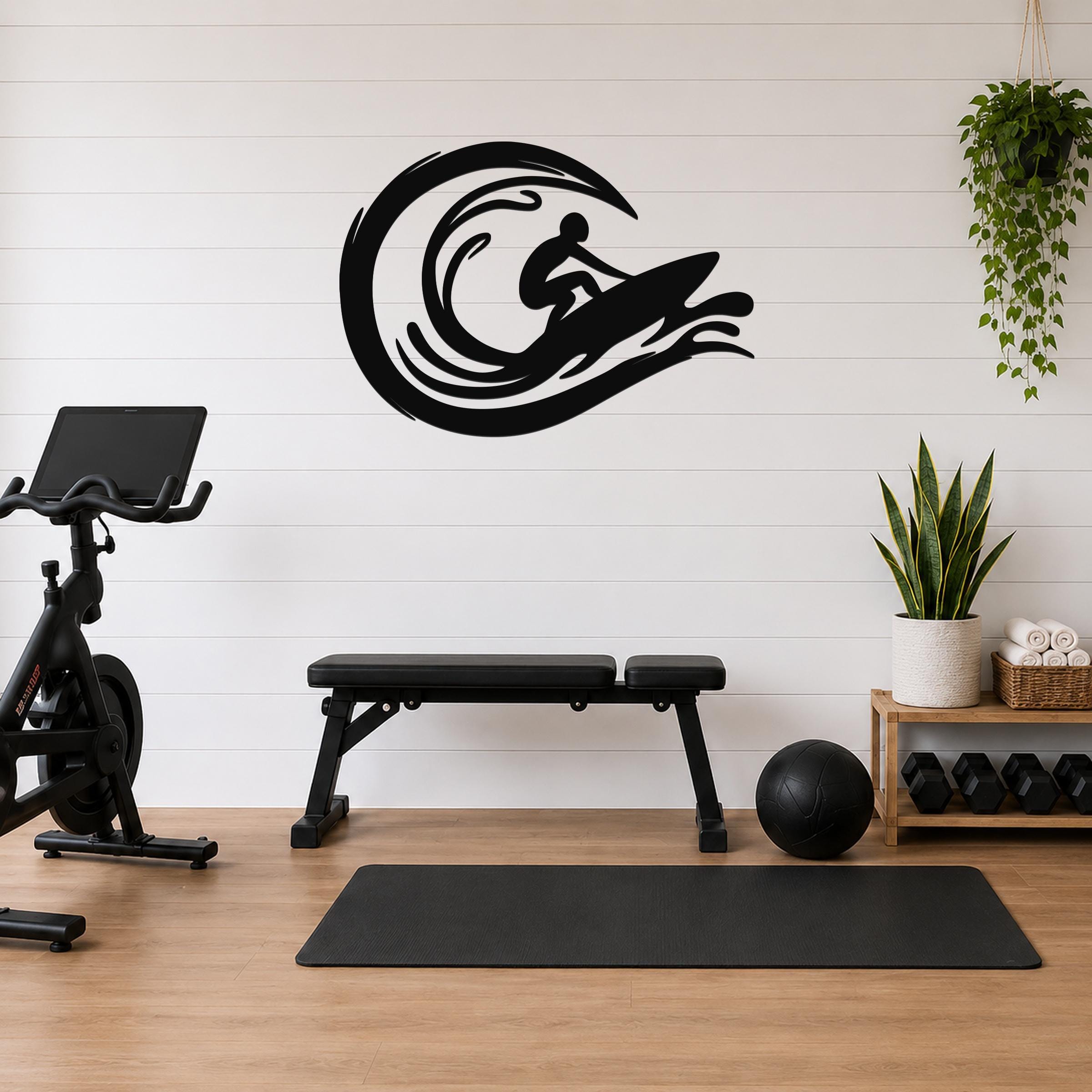 Black metal surfer wall art with wave motion cutouts, mounted on a white shiplap wall above a workout bench in a home gym.