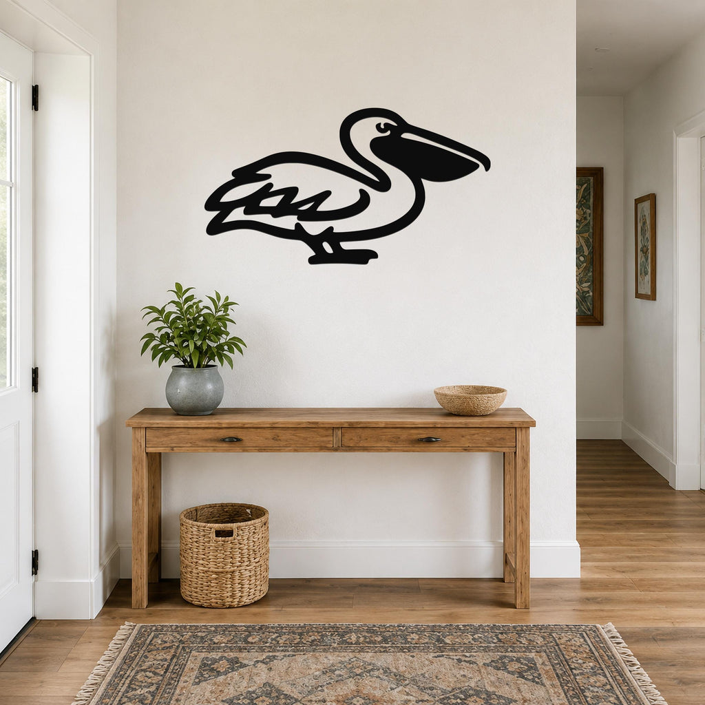 Black metal pelican wall art silhouette mounted above a wooden console table in a bright entryway.