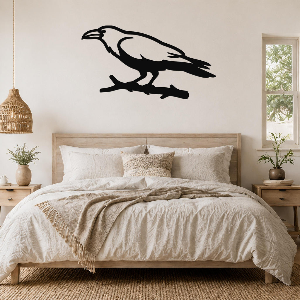 Black metal raven wall art silhouette perched on a branch, mounted above a bed in a neutral bedroom.