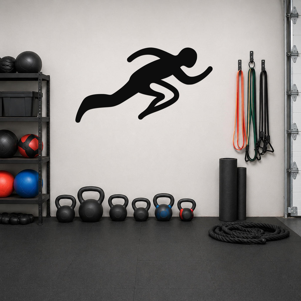 Black metal runner wall art with motion-line cutouts, mounted on a white wall above a row of kettlebells in a home gym.