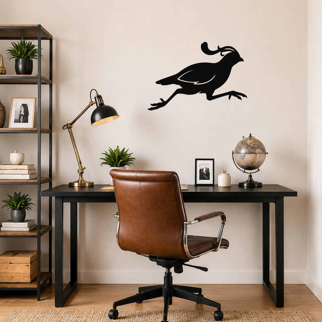 Black metal quail wall art in a running silhouette, mounted on a beige wall above a black desk in a home office.