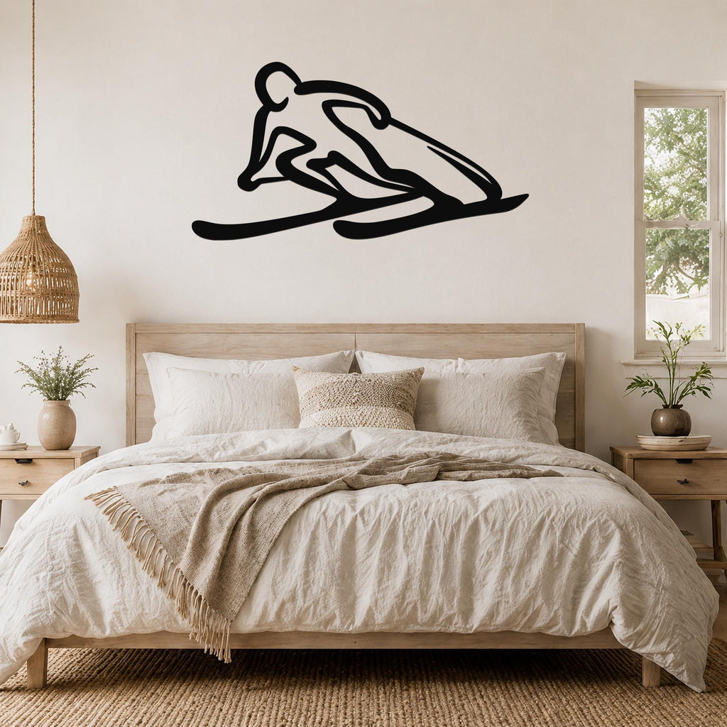 Black metal wall art of a minimalist skier silhouette, mounted above a bed in a neutral bedroom.