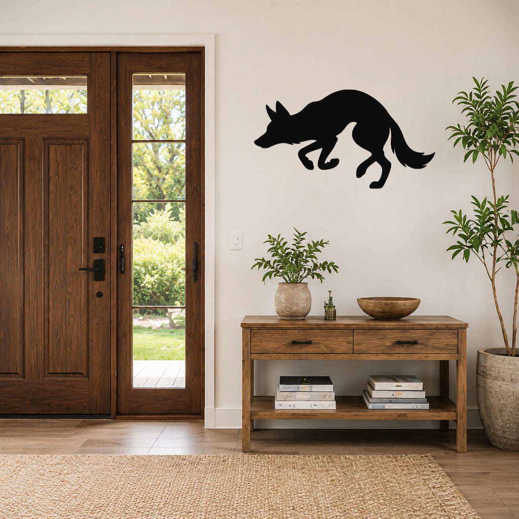 Black metal coyote wall art silhouette mounted on a living room wall above a wooden console table.