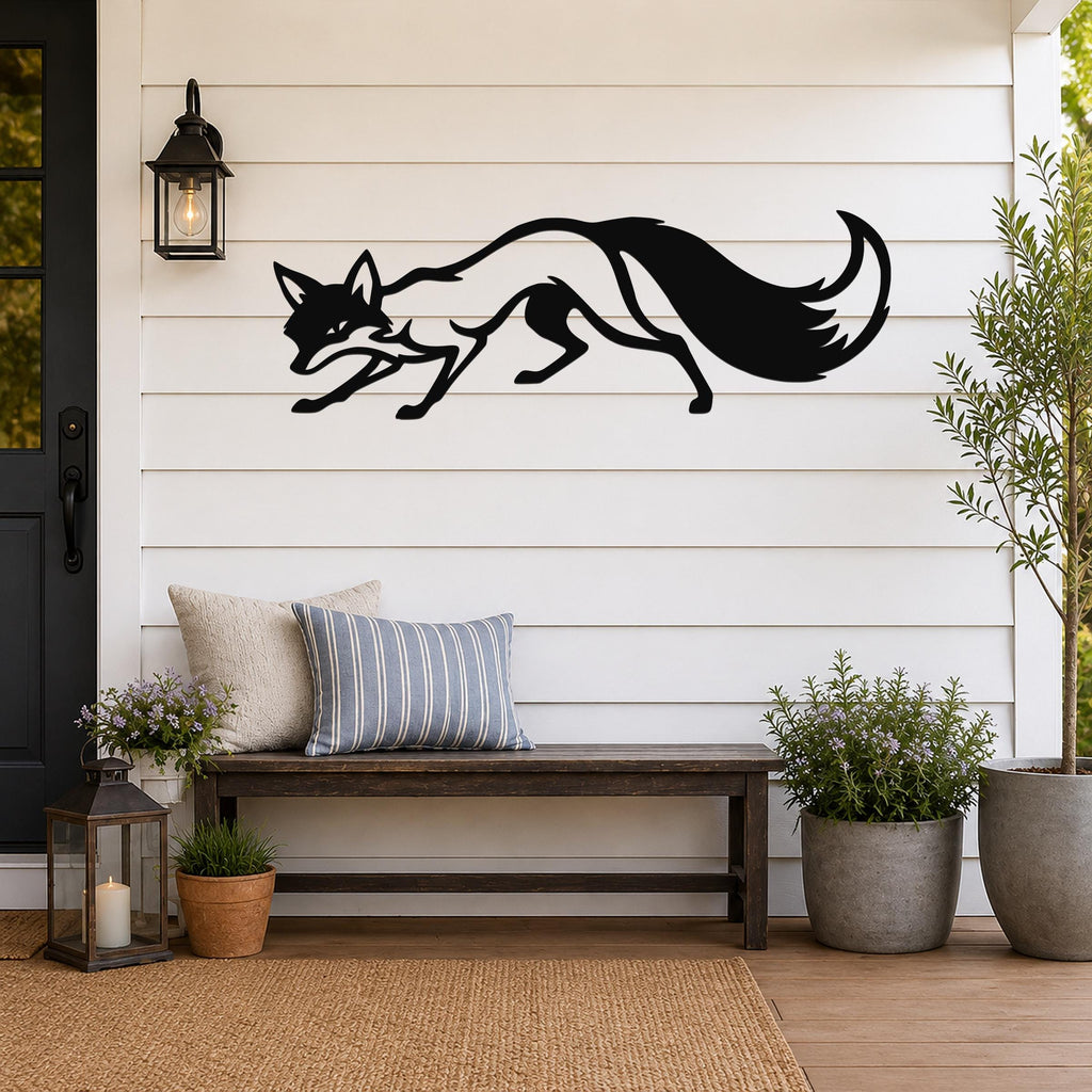 Black metal fox wall art silhouette with motion-line cutouts, mounted on a white shiplap wall above a wooden bench on a porch.