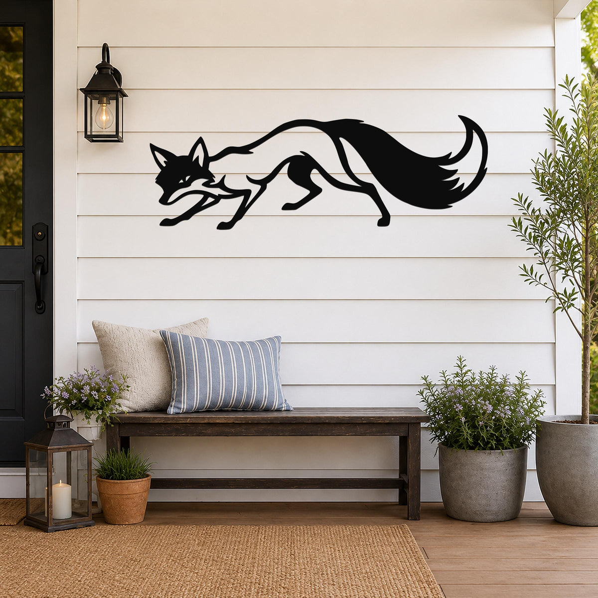 Black metal fox wall art silhouette with motion-line cutouts, mounted on a white shiplap wall above a wooden bench on a porch.