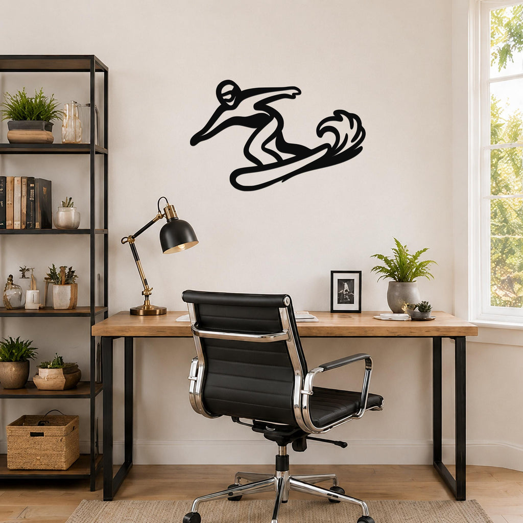 Black metal wall art silhouette of a snowboarder in motion, mounted on a wall above a wooden desk in a home office.