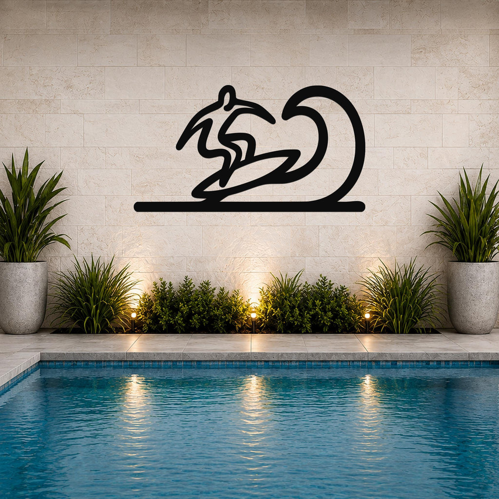 Black metal surfer wall art with a wave silhouette, mounted on a tiled wall above a pool with potted plants and ground lights.