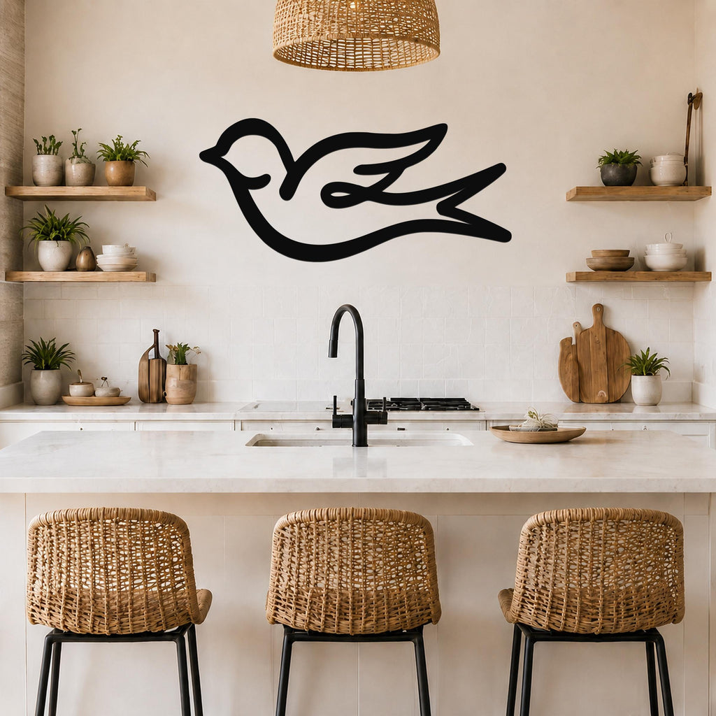 Black metal swallow bird wall art with flowing silhouette lines, mounted above a kitchen counter in a bright, modern kitchen.