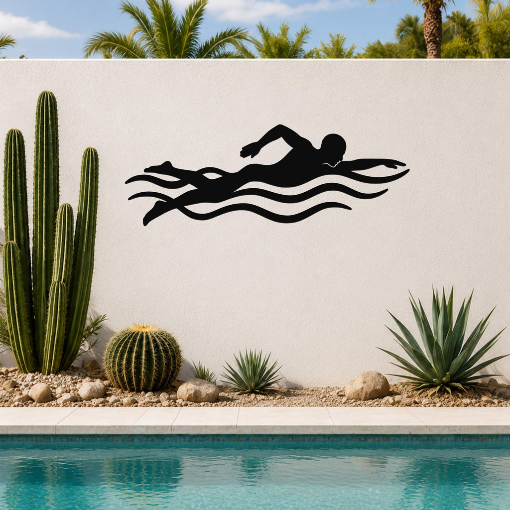 Black metal swimmer wall art with motion-line cutouts, mounted on an outdoor wall above a pool with cacti and palm trees in the background.