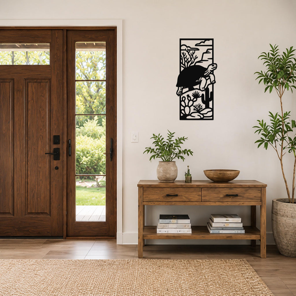 Black metal tortoise wall art with desert cactus and rock cutouts, mounted on a living room wall above a wooden console table.