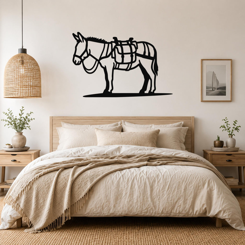 Black metal burro wall art with saddle cutouts, mounted above a bed in a neutral bedroom.