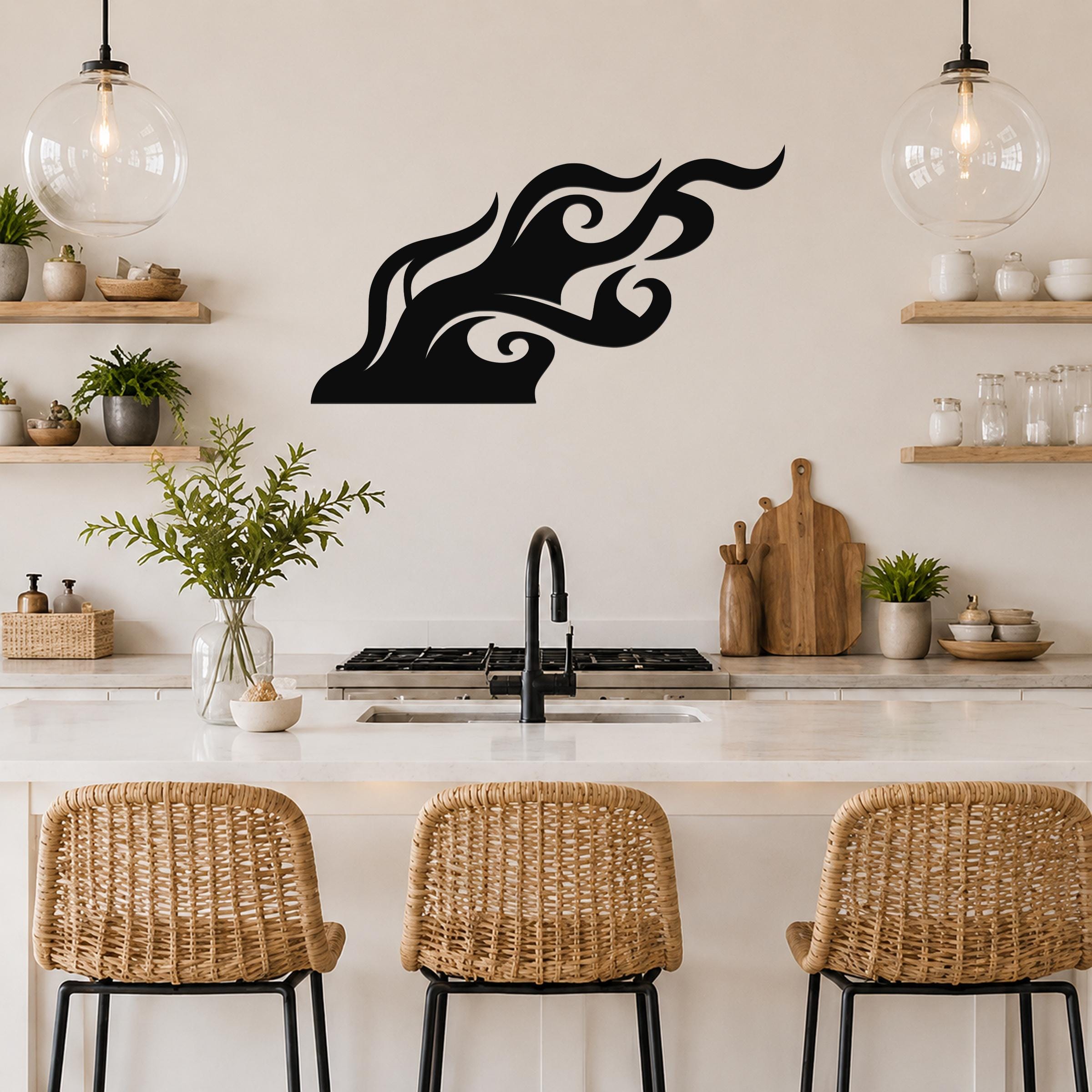 Black metal flame wall art with flowing silhouette cutouts, mounted above a kitchen counter.