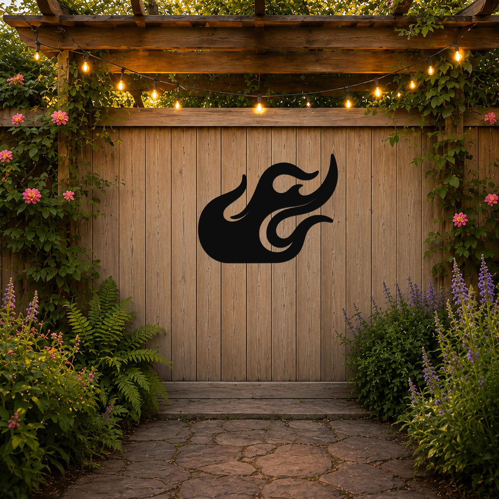 Black metal flame wall art with flowing cutout design, mounted on a wooden fence in a garden setting.