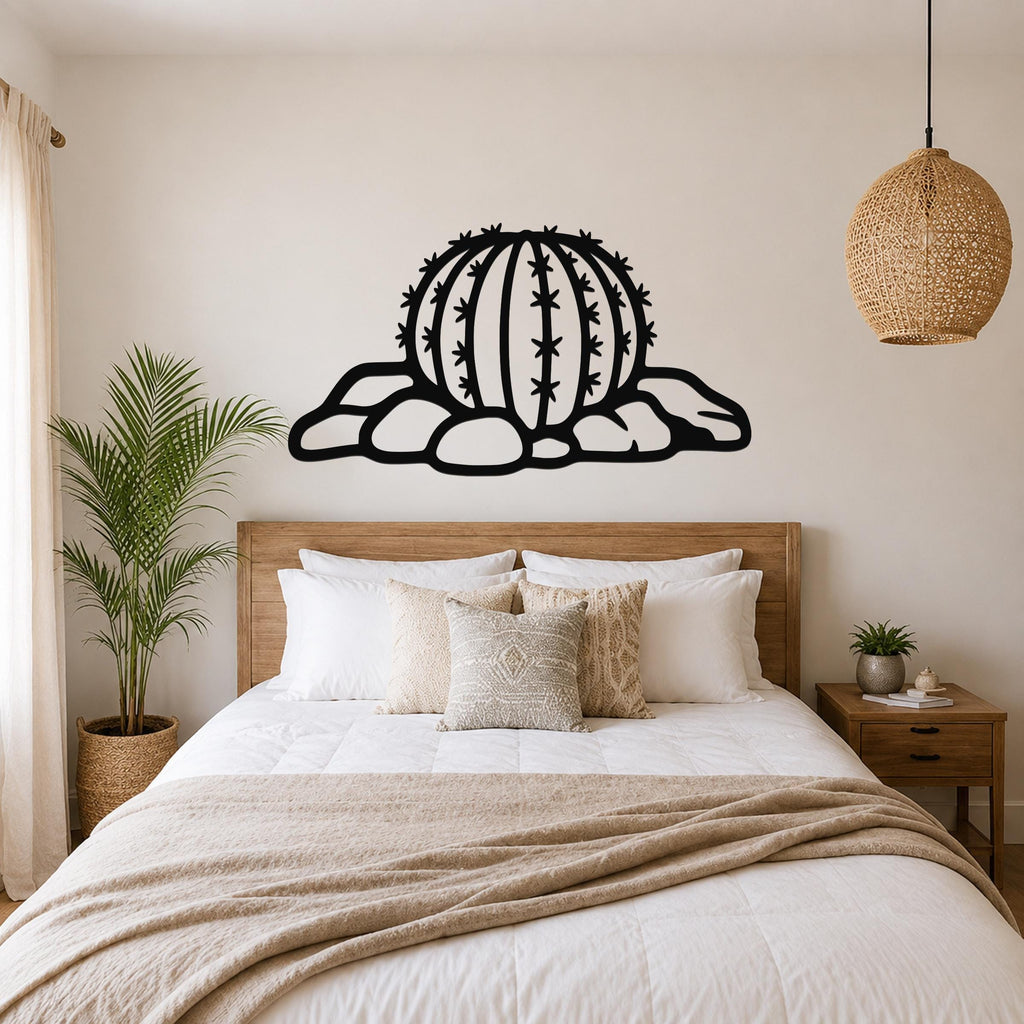 Black metal barrel cactus wall art with spines and rocks cutout, mounted above a wooden bed in a bedroom.