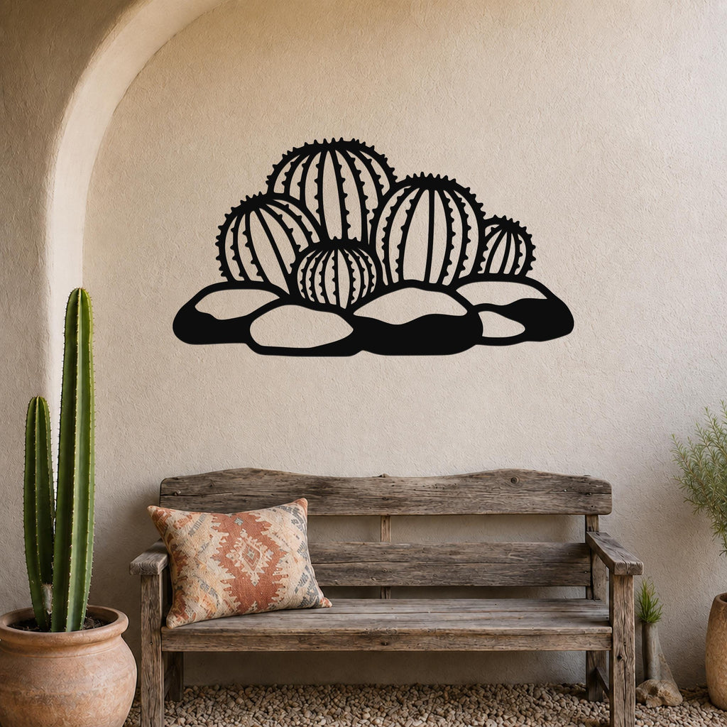 Black metal barrel cactus wall art with geometric cutouts, mounted above a wooden bench in a southwestern-style entryway.