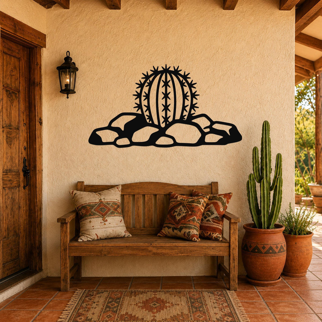 Black metal barrel cactus wall art with spines and rocks cutout, mounted on a stucco wall above a wooden bench in a patio entryway.