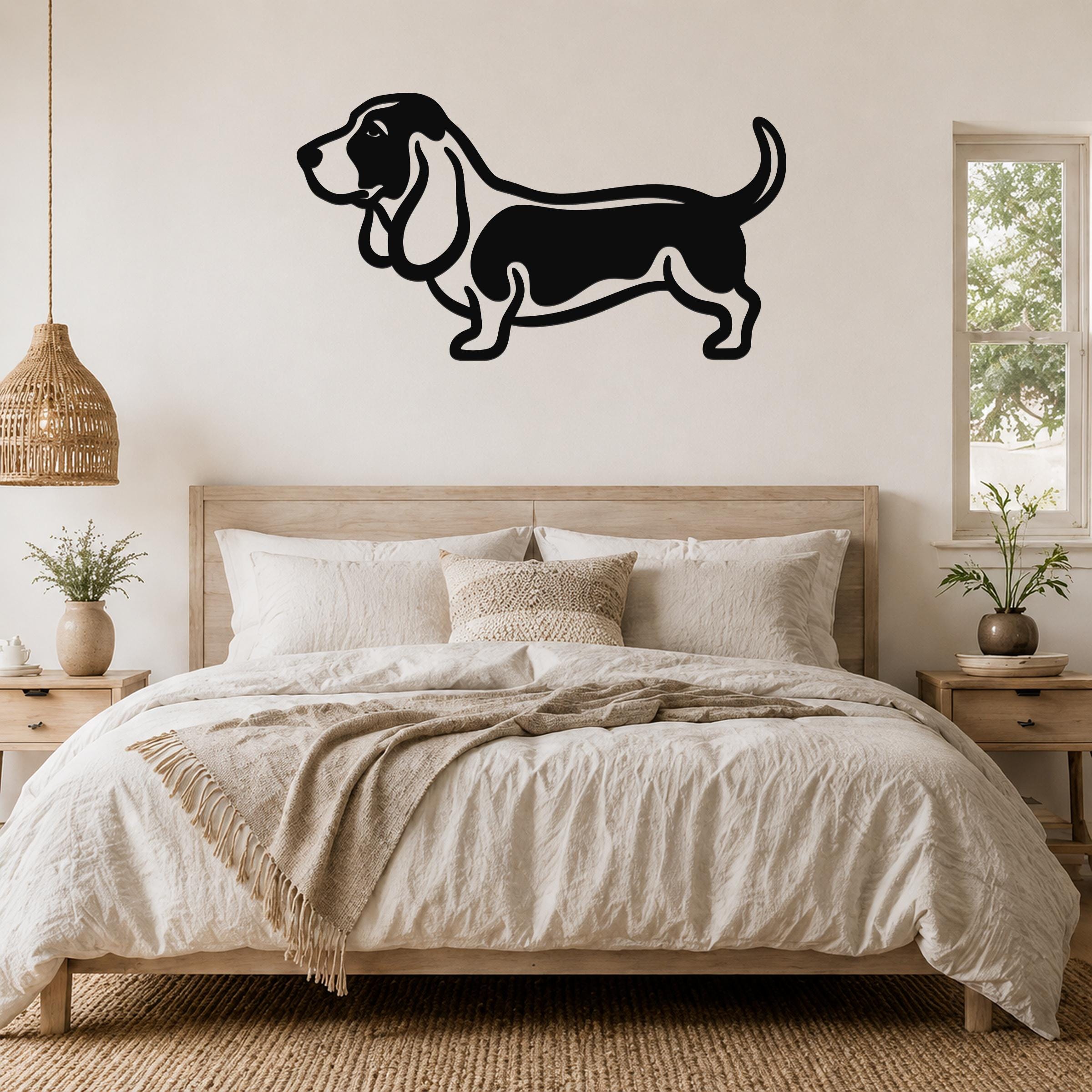 Black metal Basset Hound wall art silhouette mounted above a wooden bed in a neutral bedroom.