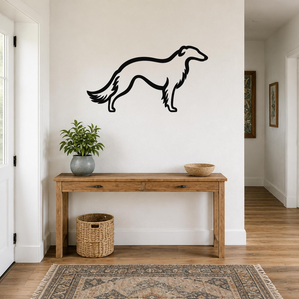 Black metal Borzoi dog wall art silhouette mounted above a wooden console table in a bright entryway.