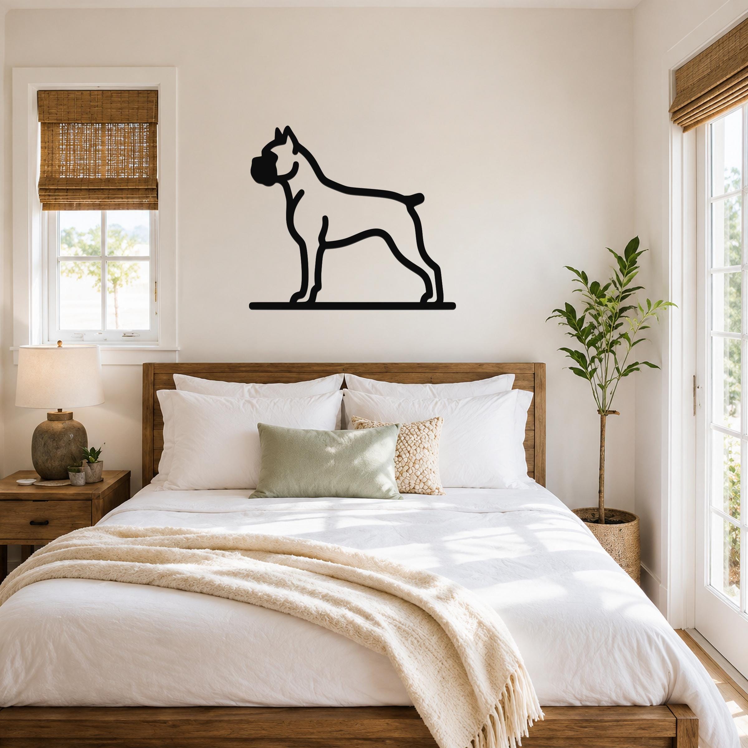 Black metal Boxer dog silhouette wall art mounted above a wooden bed in a bright bedroom.