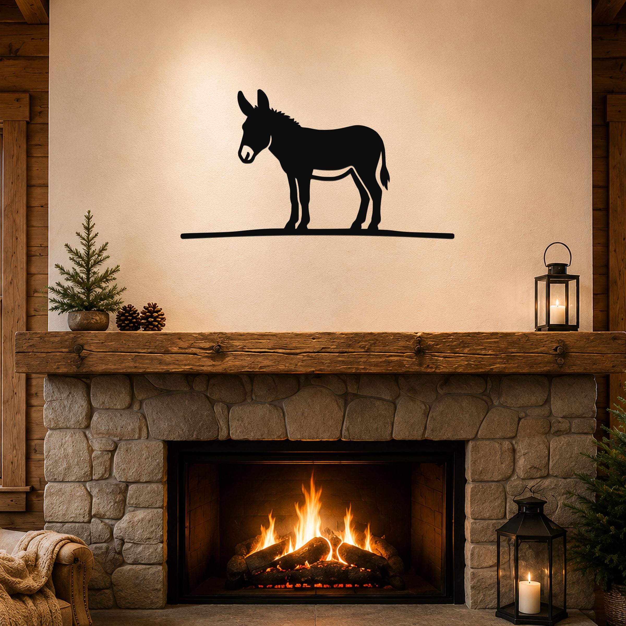 Black metal donkey wall art silhouette mounted above a stone fireplace in a rustic living room.