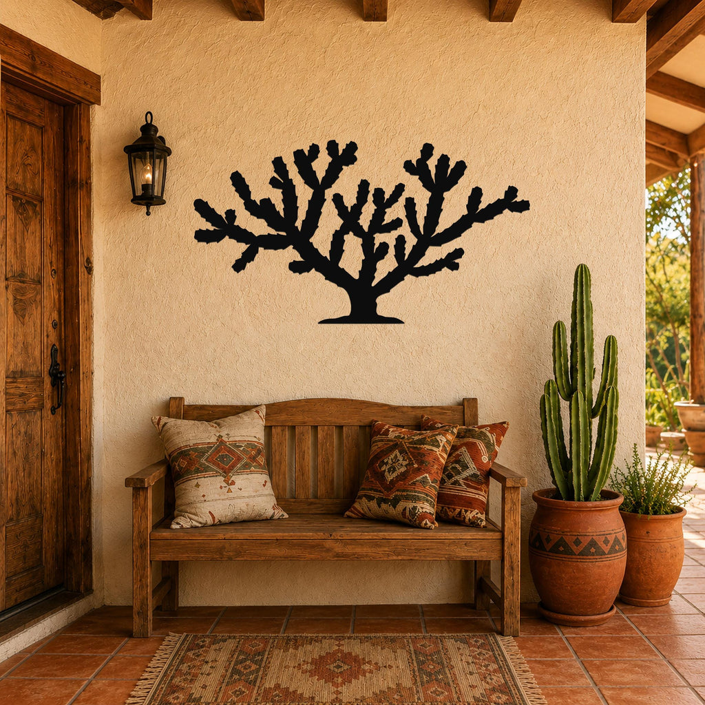 Black metal Cholla cactus wall art silhouette mounted on a stucco wall above a wooden bench in a patio entryway.