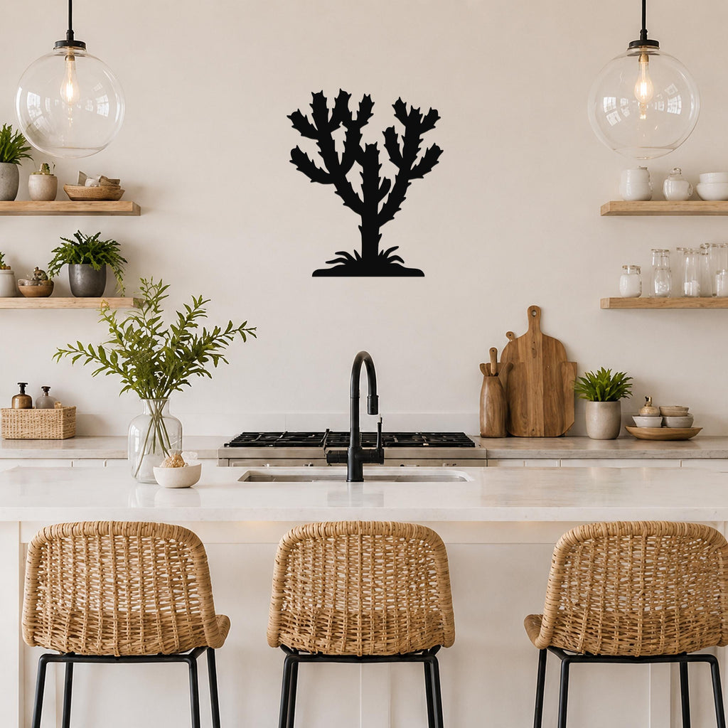 Black metal cholla cactus wall art with branching silhouette, mounted on a kitchen wall above a counter with wicker stools.