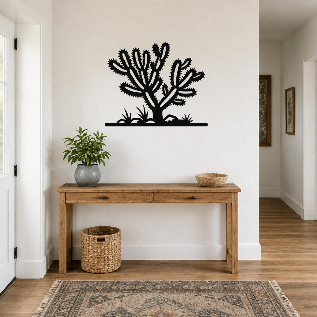 Black metal Cholla cactus wall art with spiky branch cutouts, mounted above a wooden console table in a hallway.